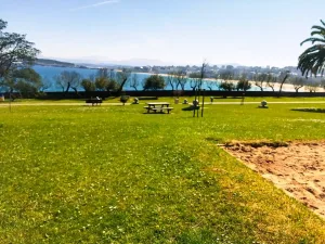 Parque con el prado muy verde y con el mar de fondo