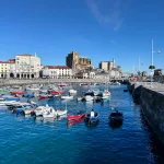 Puerto de con barcos de madera y edificios al fondo
