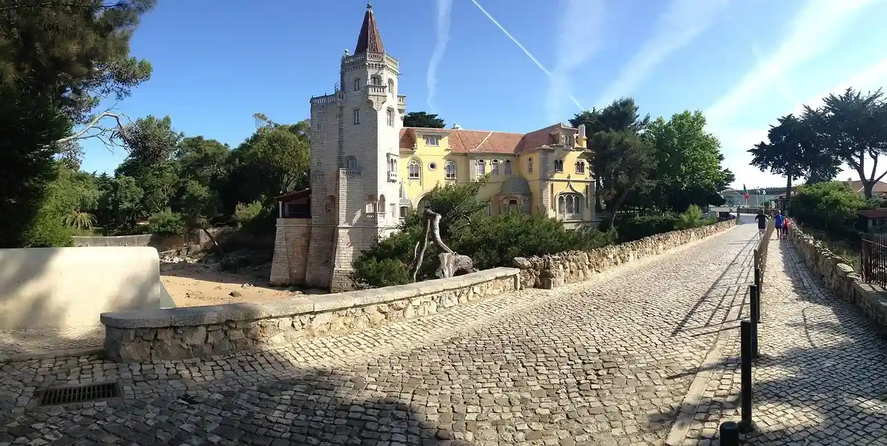 Edificio con torreón de piedra con un camino de piedra delante