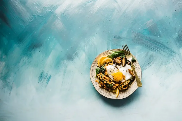 un plato con comida sobre un fondo degradado blanco y azul celeste