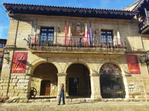 Edificio de piedra de sillería con banderas en Santillana del Mar