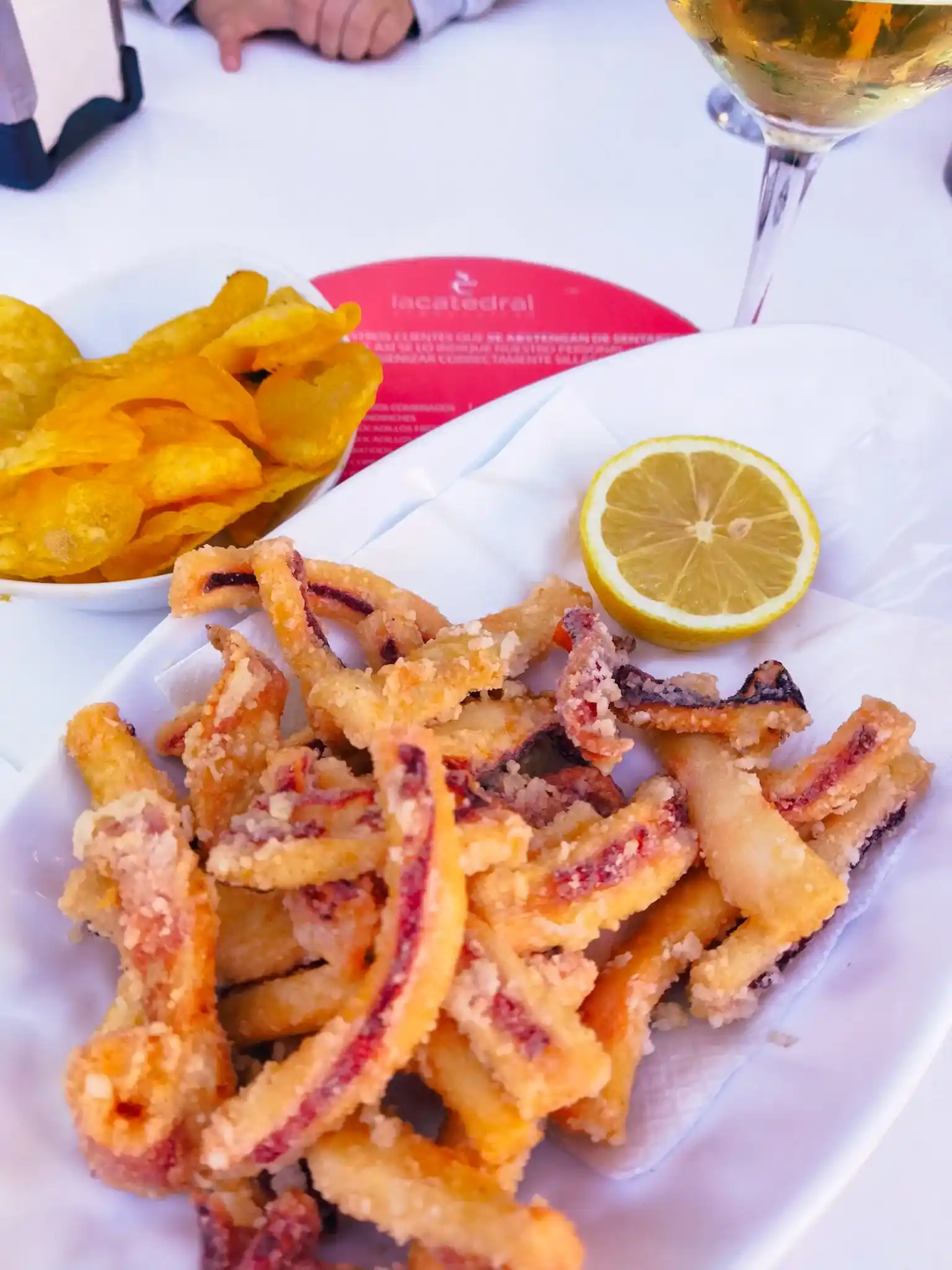 Rabas de calamar con medio limón y una copa de vino blanco del post las cafeterías con más encanto en Santander