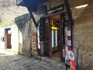 Edificio de piedra de sillería con una entrada de madera a una repostería sin gluten en Santillana del Mar