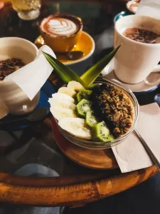 Bol de cereales con kiwi y tres cafés al fondo del post las cafeterías de Santander con más encanto