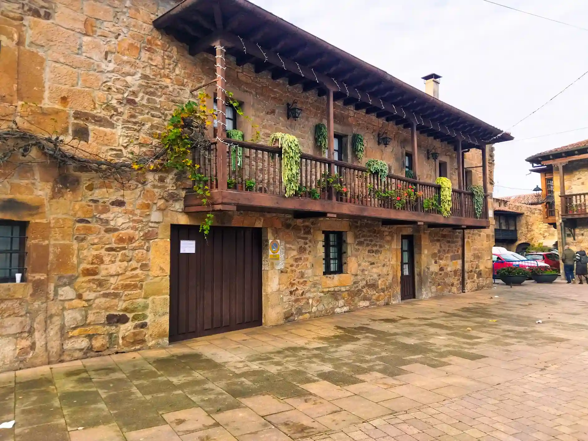 Casona de piedra con balconada de madera y flores