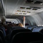 Niño intentando tocar el botón de llamada en un avión
