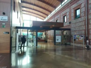 Zona de recepción de una biblioteca con la fachada de piedra y ladrillos rojos