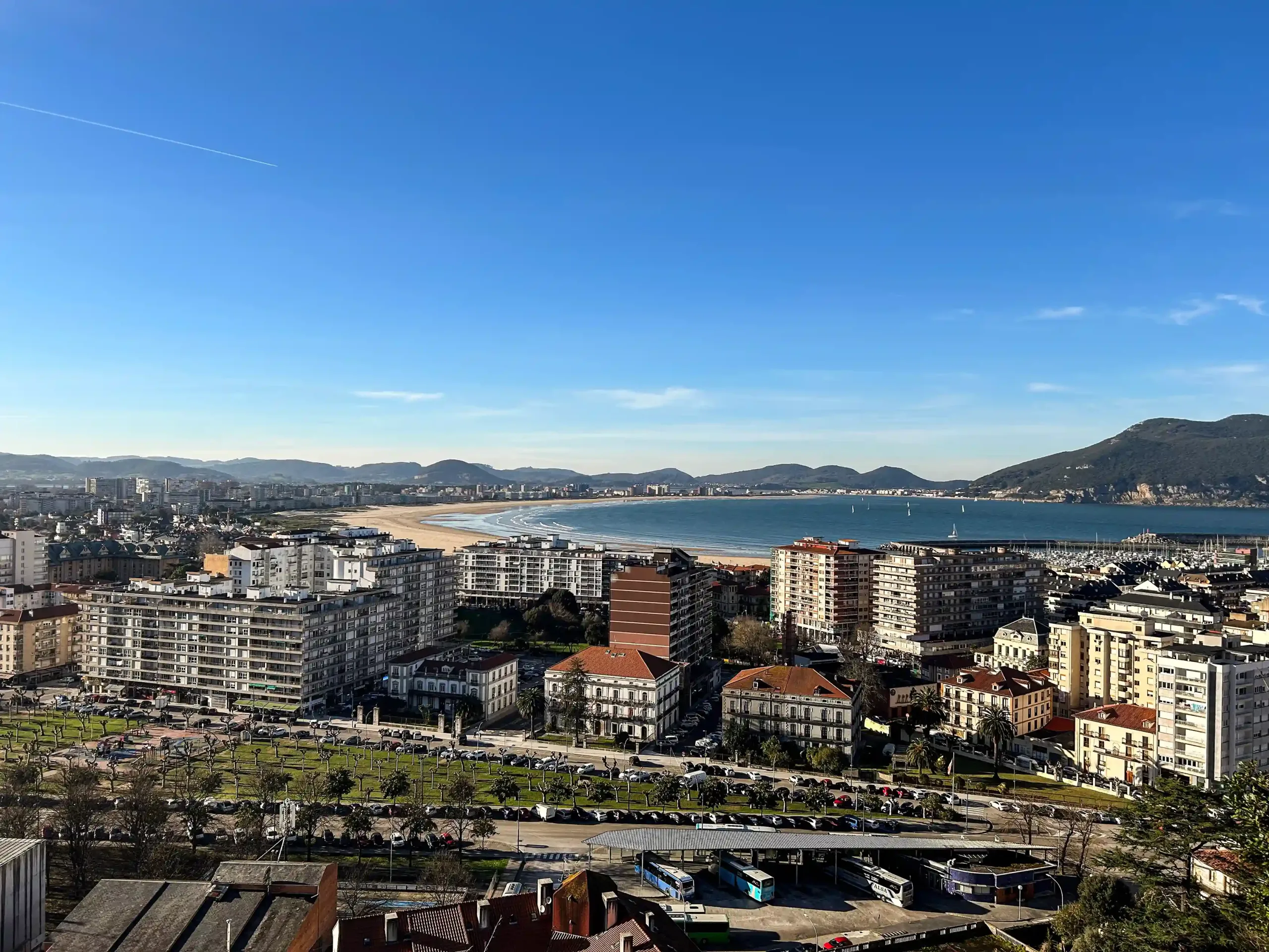 Conjunto de edificios visto de un mirador con una playa al fondo