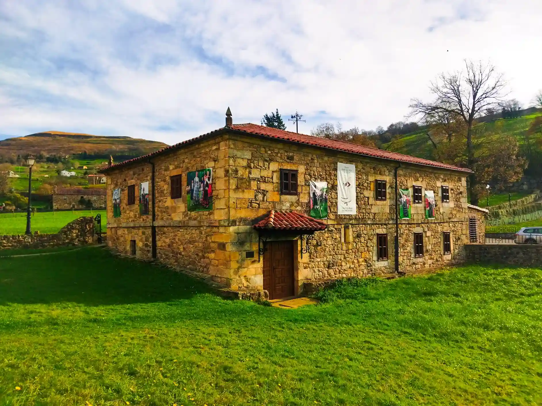 casa de piedra con prado verde a los lados. Ruta circular en coche por los valles pasiegos.