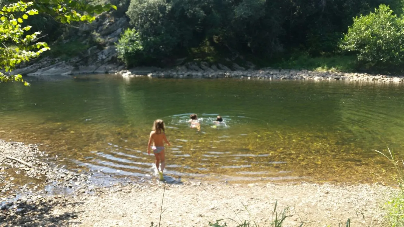 Poza de un río con tres niñas dentro