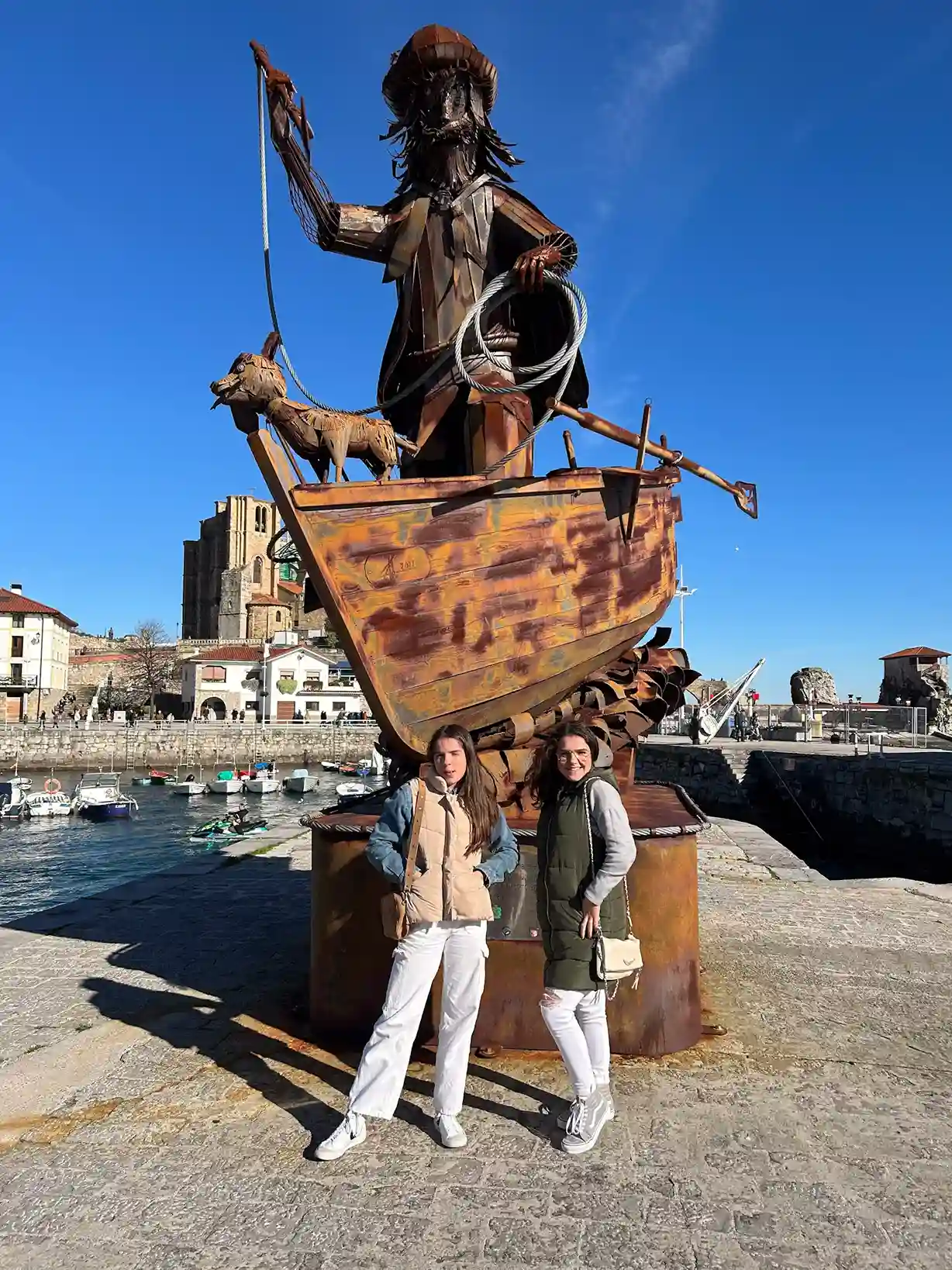 Estatua de acero de un ballenero con dos chicas