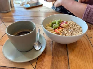 Café con bol de avena sin gluten y frutas