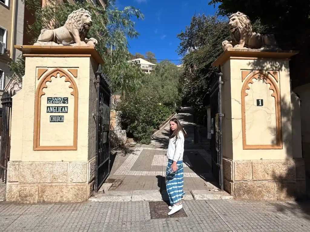 Chica posando a la entrada de un cementerio
