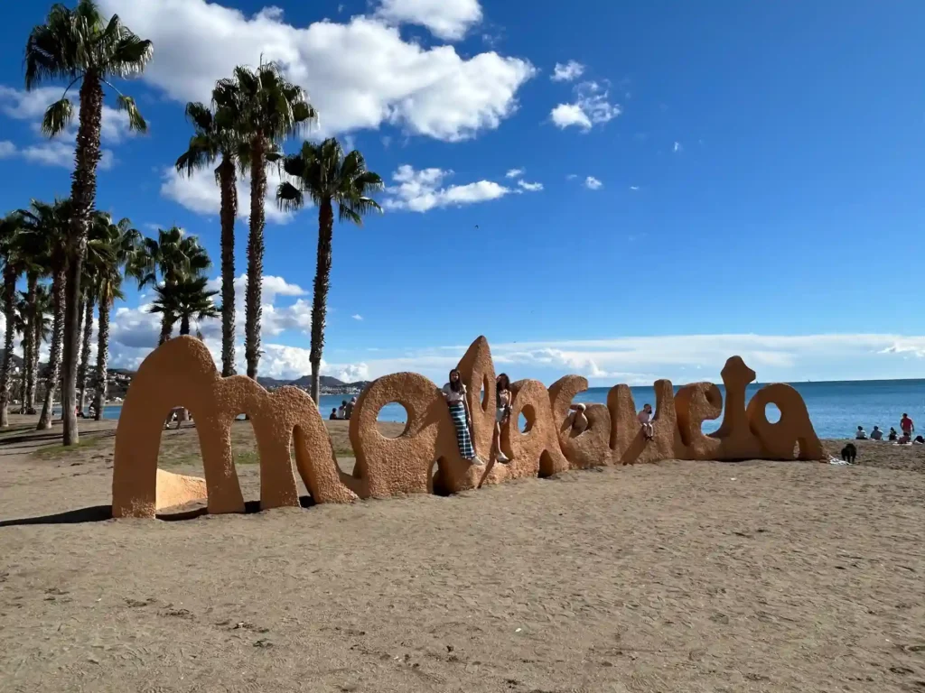 Letras de una playa con gente en ellas. Playa de la Malagueta 