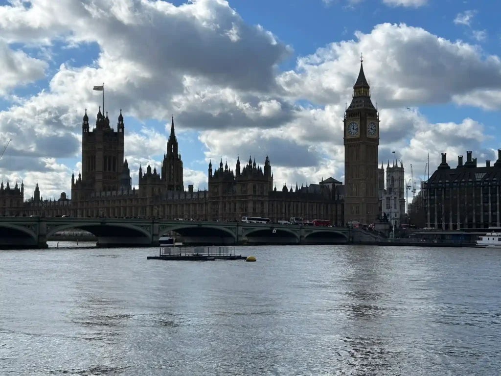 Río muy grade con un edificio antiguo y una torre con un reloj. Río Támesis con el Parlamento y Big Ben de fondo Fuente: glutendtrotters.com