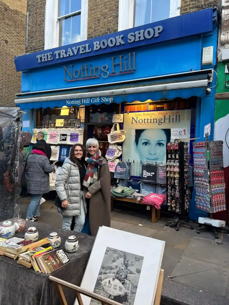 Madre e hija posando delante una tienda de color azul que vende guías de viaje

Mítica librería de guías de viajes de la película Notting Hill

Fuente: glutendtrotters.com