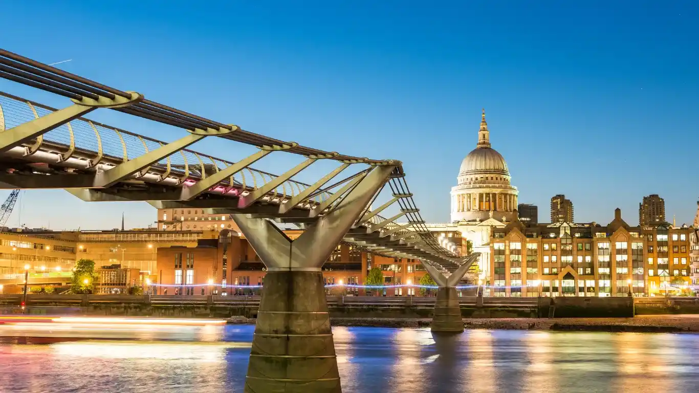 Puente moderno con una catedral al fondo Milennium Bridge y la cúpula del St Paul Cathedral Fuente: canva.com