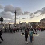 Plaza muy grande con mucha gente y una escultura en lo alto de una torre Trafalgar Square Fuente: glutendtrotters.com