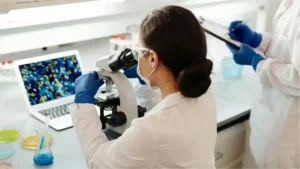 científica mirando por un microscopio