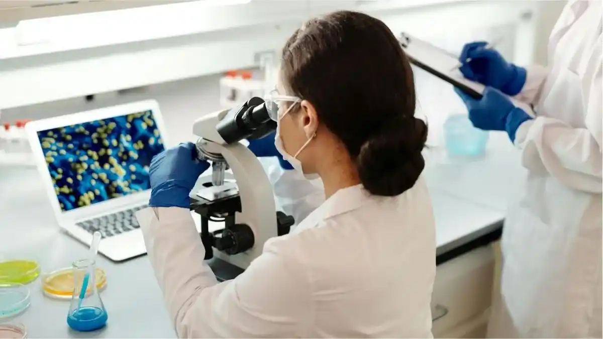 científica mirando por un microscopio
