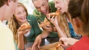 Grupo de adolescentes comiendo una pizza