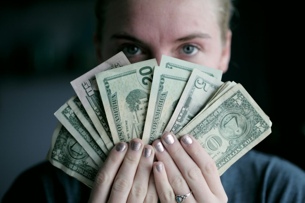 Mujer con billetes de dólar haciendo un abanico