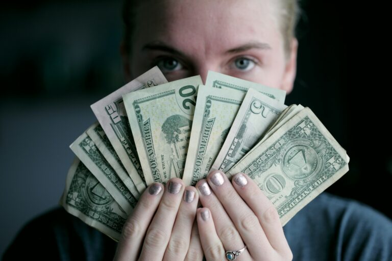 Mujer con billetes de dólar haciendo un abanico
