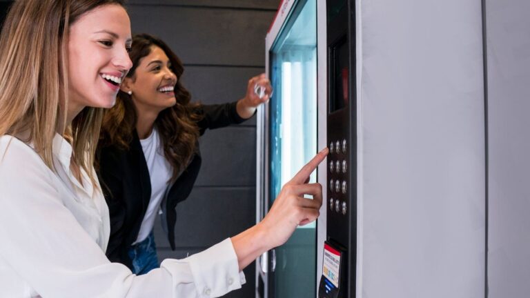 Chicas comprando en una máquina de vending