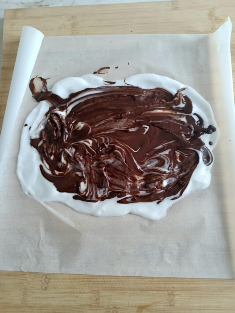 chocolate negro derretido esparciéndose sobre el yogur para preparar la corteza sin gluten