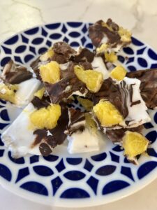 corteza de yogur sin gluten con chocolate negro y naranja servida en un plato
