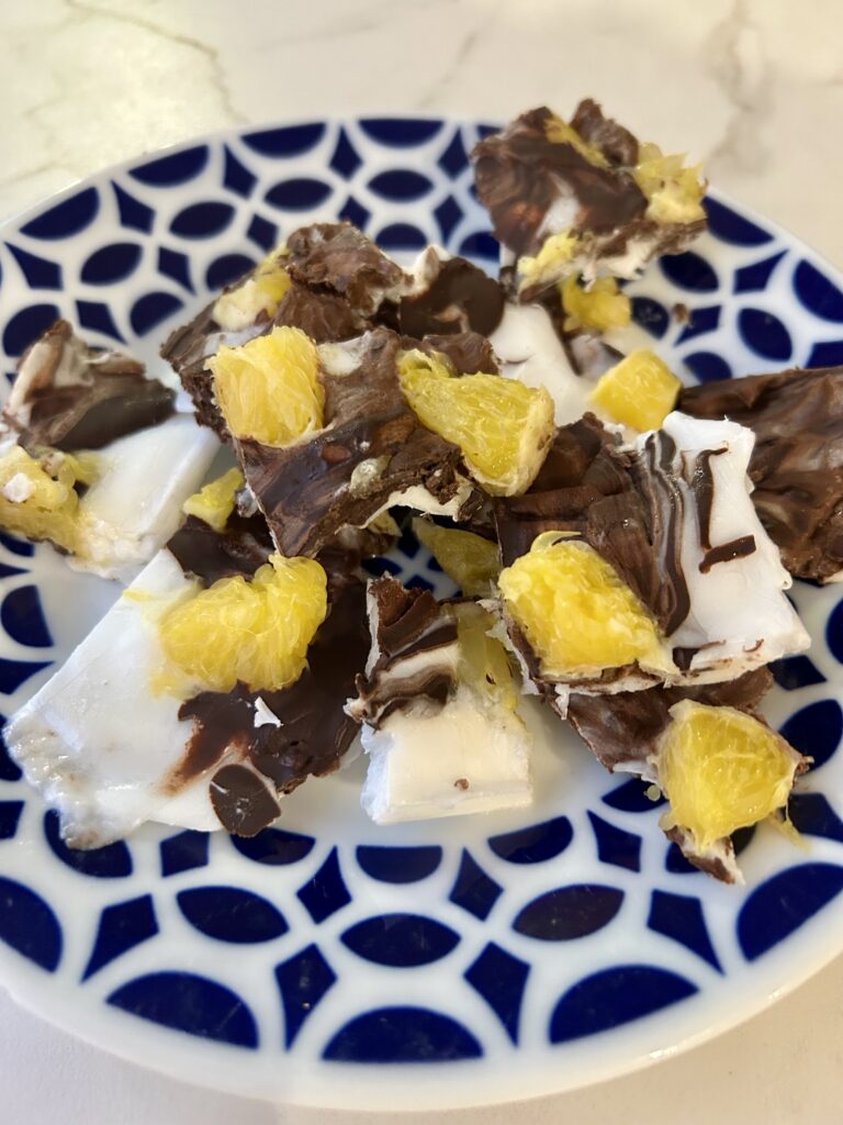 corteza de yogur sin gluten con chocolate negro y naranja servida en un plato