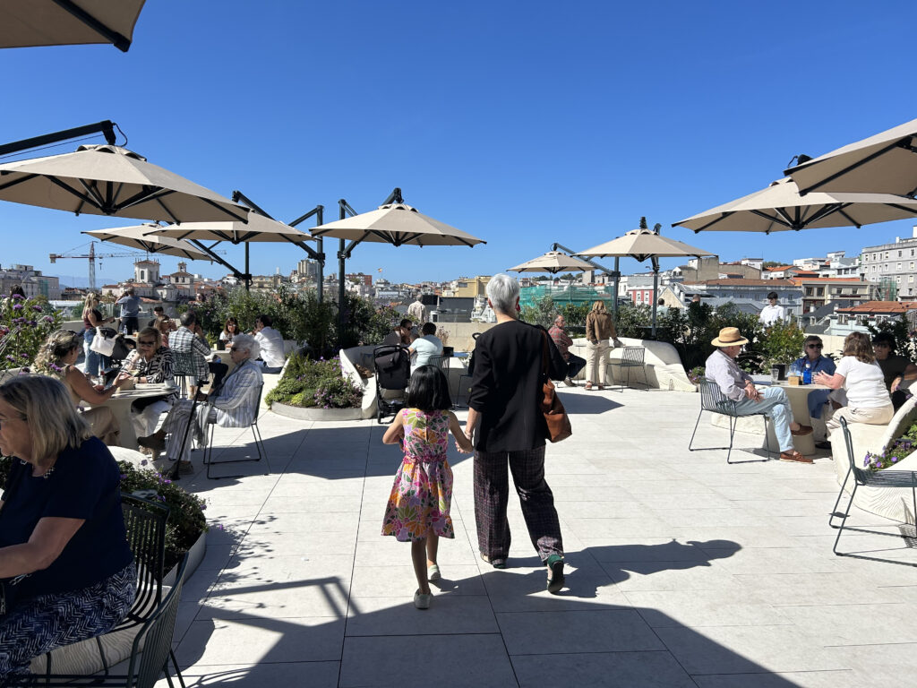 Terraza con con personas y una mujer y una niña en medio. Faro Santander
