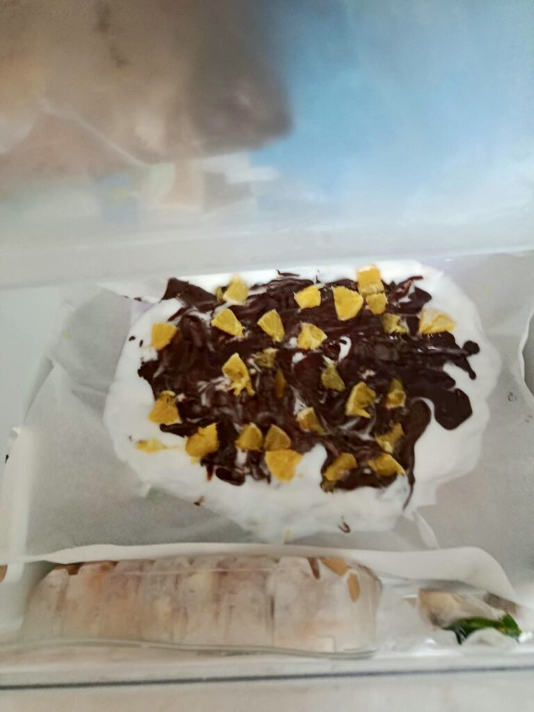 corteza de yogur con chocolate negro y trozos de naranja lista para congelar
