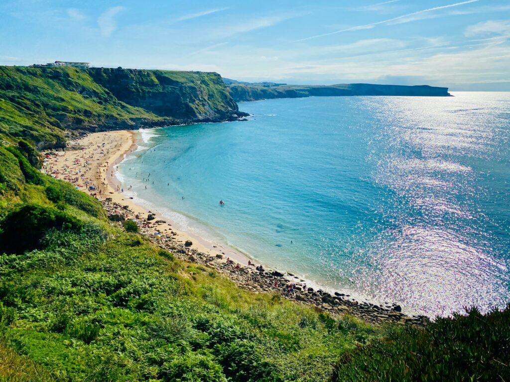 Los Locos Beach in Suances, Cantabria, with green meadows beside the sea